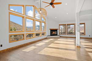 Unfurnished living room with a mountain view, beamed ceiling, a wealth of natural light, and light hardwood / wood-style flooring