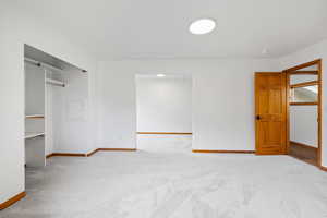 Unfurnished bedroom featuring light colored carpet and a closet