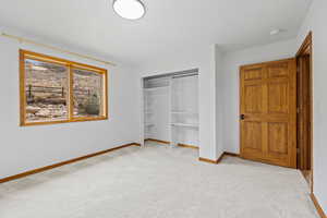 Unfurnished bedroom with a closet and light colored carpet