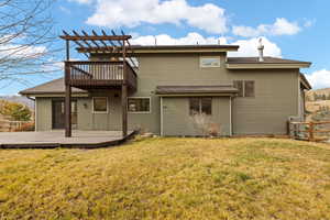 Back of house featuring a yard and a deck