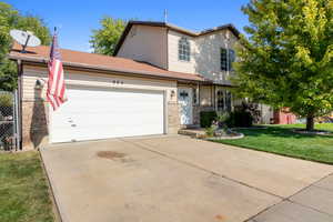 View of front of home with a front yard and a garage