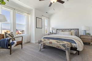 Carpeted bedroom with ceiling fan and vaulted ceiling