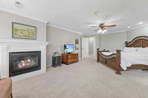 Bedroom featuring ceiling fan, light carpet, and crown molding