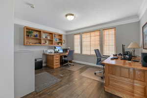 Home office with a textured ceilings, laminate/wood-style floors, and ornamental molding