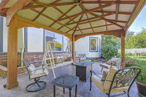 View of patio with a gazebo and an outdoor living space with a fire pit