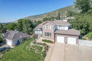 View of front of house featuring a mountain view, a front yard, and a garage