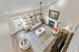 Living room featuring vaulted ceiling, laminate/wood-style floors, and ceiling fan