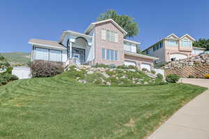 View of front facade with a garage and a front lawn