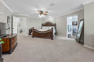 Bedroom featuring ornamental molding, light colored carpet, and ceiling fan