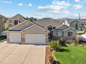 View of front of property featuring a 4 car garage with tandem 3rd with a 10w x 9h door and  front yard