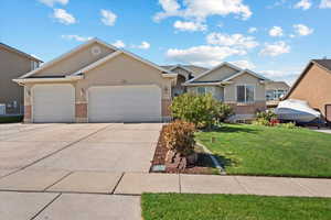 Single story home featuring a front yard and a garage