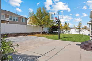 View of sport court with a yard