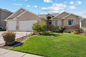 View of front of property featuring a 4 car garage with tandem 3rd with a 10w x 9h door and  front yard