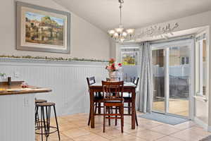 Tiled dining space featuring a notable chandelier