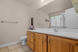 Bathroom featuring toilet, vanity, and tile patterned floors