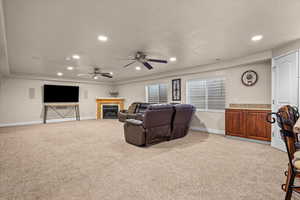 Carpeted living room with a textured ceiling and ceiling fan