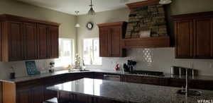 Kitchen with sink, stainless steel dishwasher, pendant lighting, gas cooktop, and decorative backsplash