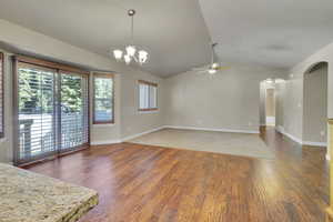 Interior space featuring dark hardwood / wood-style flooring, a textured ceiling, ceiling fan with  and vaulted ceiling