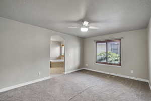 Master Bedroom featuring a textured ceiling, light colored carpet, and ceiling fan