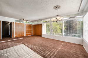 Interior space with ceiling fan with notable chandelier