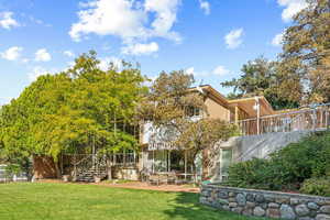 Rear view of property with a patio and a lawn