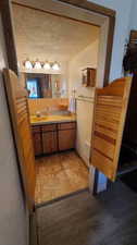 Bathroom featuring hardwood / wood-style floors, vanity, and a textured ceiling