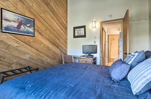 Bedroom featuring wood walls