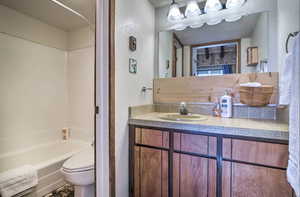 Full bathroom featuring shower / tub combination, vanity, and toilet