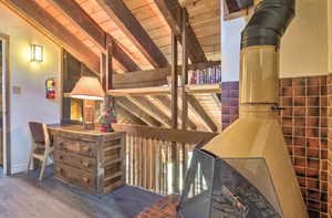 Interior space with lofted ceiling with beams, hardwood / wood-style flooring, and wood ceiling