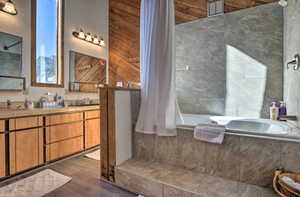 Bathroom featuring wood-type flooring, vanity, and independent shower and bath