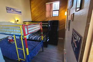 Bedroom featuring wood walls and wood-type flooring