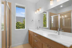 Primary Bathroom with vanity, a shower with shower door, and tile patterned flooring