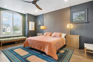 Bedroom with ceiling fan, multiple windows, and light wood-type flooring