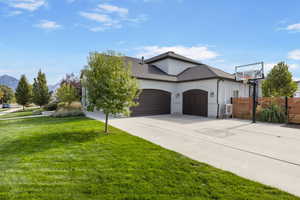 View of front of home featuring a mountain view, a front yard, and a garage