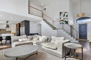 Living room with dark wood-type flooring and a towering ceiling