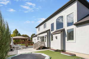 Back of property featuring a gazebo, a patio, and an outdoor hangout area