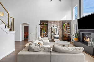 Living room with a high ceiling and dark hardwood / wood-style flooring