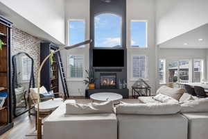 Living room featuring a towering ceiling and light wood-type flooring