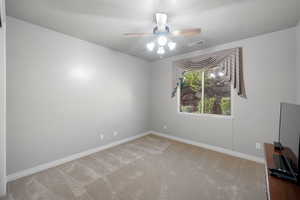 Carpeted empty room with ceiling fan