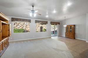 Unfurnished living room featuring vaulted ceiling, ceiling fan, a textured ceiling, and light tile patterned floors