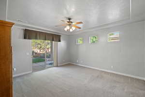 Spare room featuring light carpet, a textured ceiling, and ceiling fan