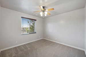 Empty room with carpet flooring and ceiling fan