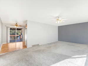 Carpeted spare room with ceiling fan