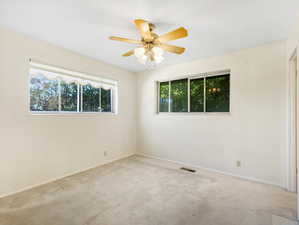 Carpeted empty room with ceiling fan