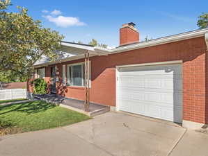 Ranch-style house with a garage and a front lawn