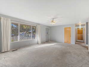 Carpeted spare room with ceiling fan