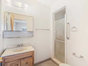 Bathroom featuring vanity, walk in shower, and toilet