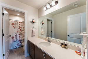 Bathroom with vanity, toilet, tile patterned floors, and walk in shower