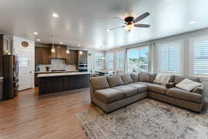 Living room with light hardwood / wood-style flooring and ceiling fan