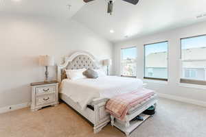 Carpeted bedroom with lofted ceiling and ceiling fan